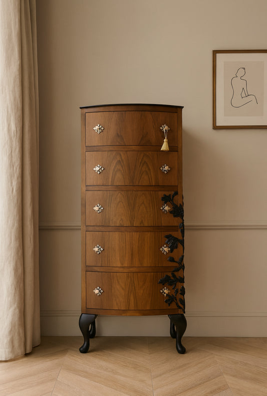 Wooden chest of drawers against a beige wall with a framed picture.