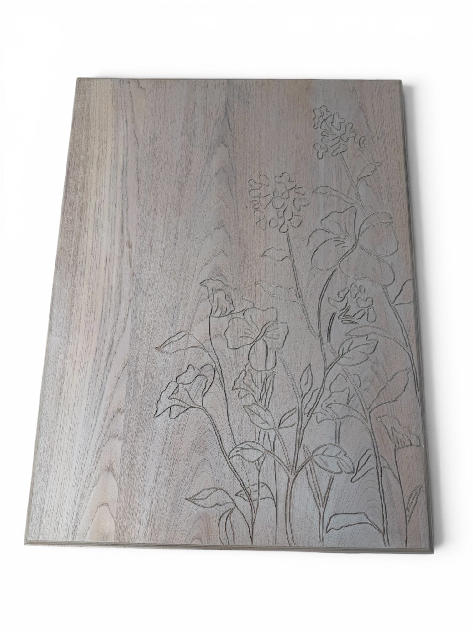 A rectangular coffee table with subtle grain texture and engraved floral line art on the right side.